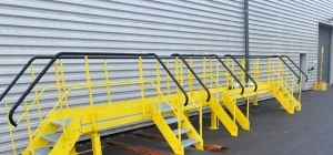 Passerelle et escaliers d'accès industriels en acier peint jaune, fabriqués et posés par SII Ardennes